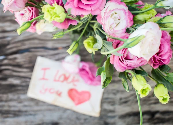 내가 당신을 사랑 하는 메시지와 함께 나무 테이블에 Lisianthus 꽃다발 — 스톡 사진