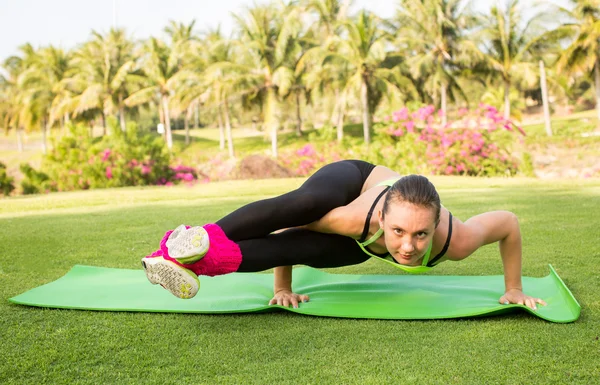 Mujer joven haciendo yoga en el parque matutino — Foto de Stock