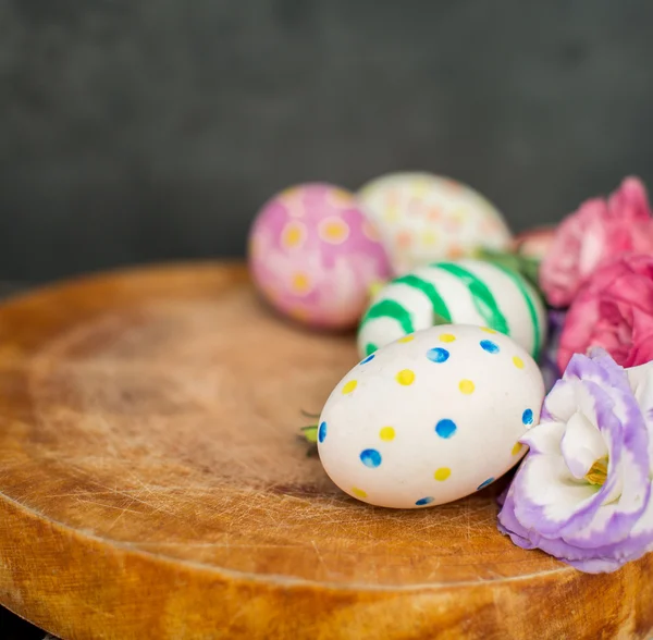 Πολύχρωμα Πασχαλινά αυγά και το lisianthus στο ξύλινο τραπέζι — Φωτογραφία Αρχείου