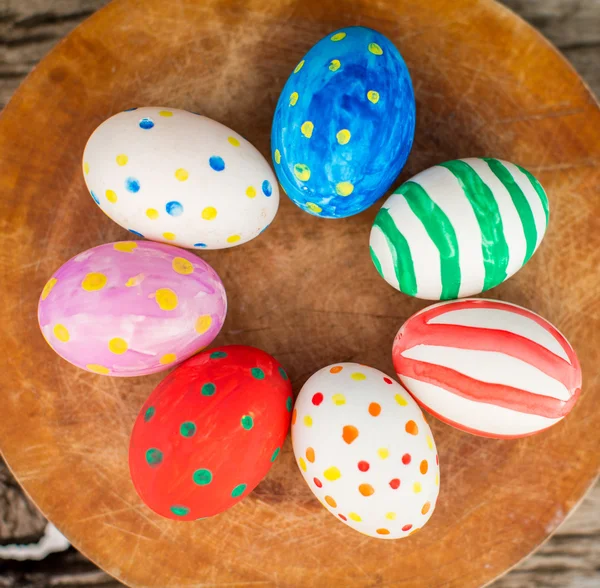 Uova di Pasqua colorate e su tavolo di legno — Foto Stock