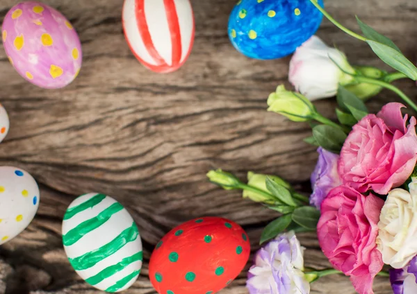 Uova di Pasqua colorate e lisianthus sul tavolo di legno — Foto Stock