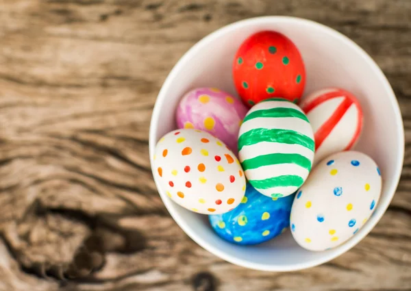Uova di Pasqua colorate e su tavolo di legno — Foto Stock