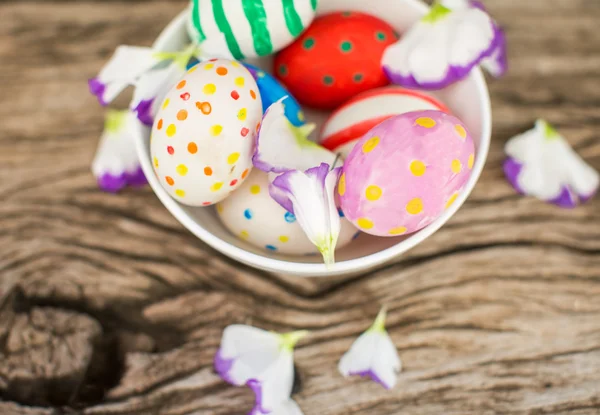 Uova di Pasqua colorate e lisianthus sul tavolo di legno — Foto Stock