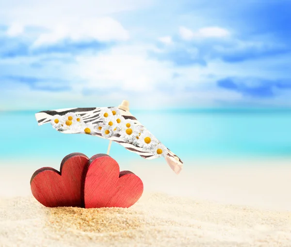 Deux cœurs sous le parapluie sur une plage de sable — Photo