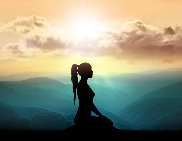Silhouette girl meditates on a background of mountains — Stock Photo, Image