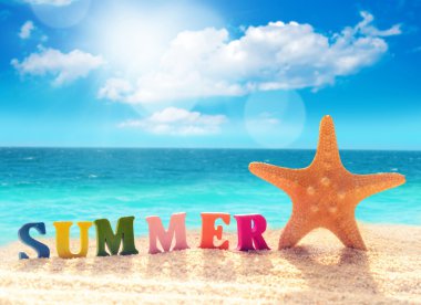 Harfler ve denizyıldızı plaj kum üzerinde.