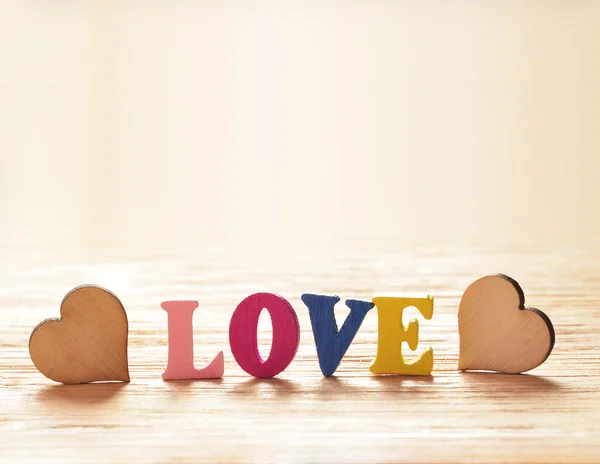 Hjärtan på trä bakgrund med bokstäver kärlek — Stockfoto