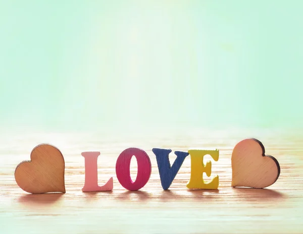 Hjärtan på trä bakgrund med bokstäver kärlek — Stockfoto