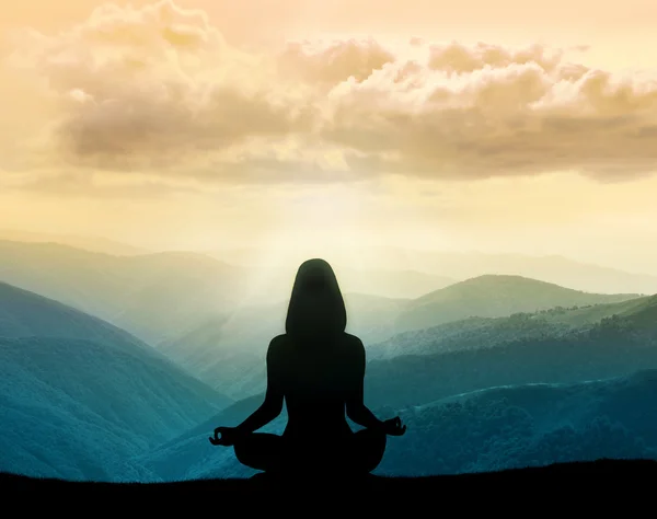 Yoga y meditación. Silueta de mujer en las montañas — Foto de Stock