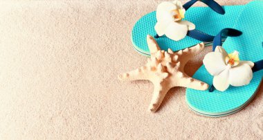 Kum deniz yıldızı ile Flip Floplar. Yaz .beach kavramı.