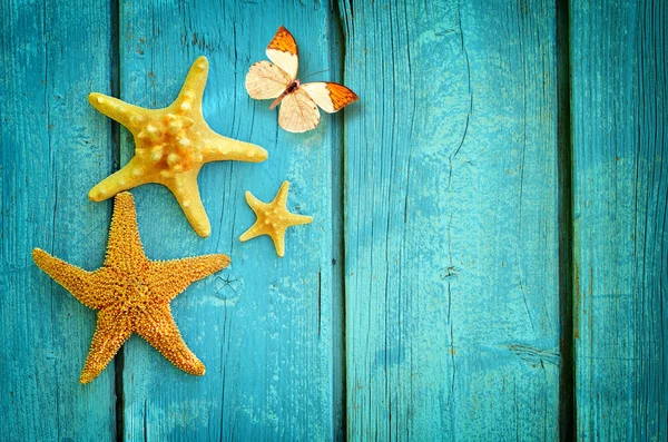 Starfish e borboleta no fundo de madeira azul. Conceito de verão . — Fotografia de Stock