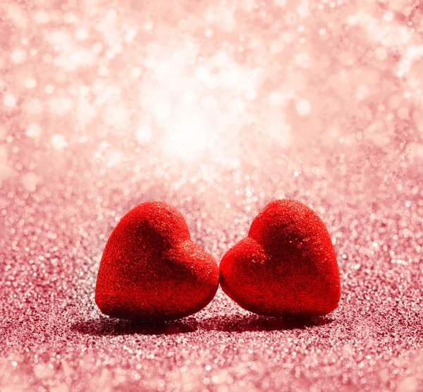 Deux cœurs rouges sur fond abstrait de lumière scintillante — Photo