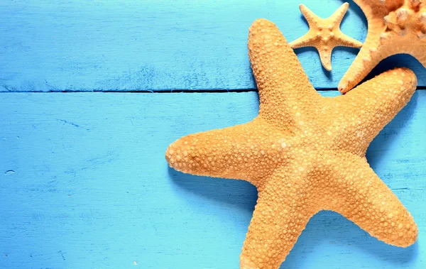 Estrella de mar sobre un fondo azul de madera . — Foto de Stock