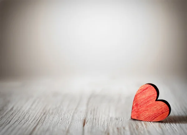 Corazón rojo sobre tabla de madera contra luces desenfocadas . —  Fotos de Stock