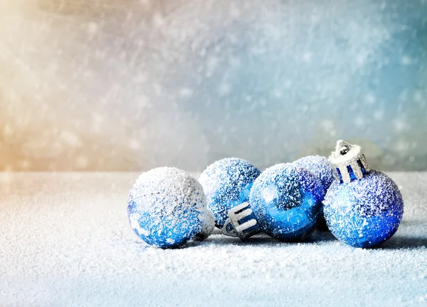 Bolas de Natal brilhantes no fundo nevado . — Fotografia de Stock