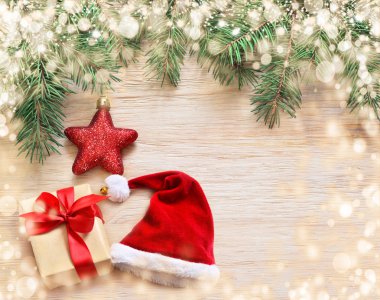Çam, santa şapka ve ahşap arka plan üzerinde hediye kutusu.