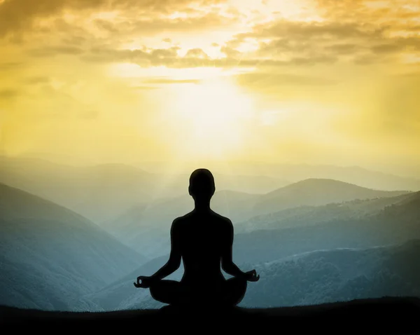 Yoga silhouette on the mountain in rays of the dawn — Stock Photo, Image