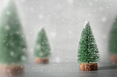 Dekoratif köknar ağacı, ahşap kızak ve gri zeminde kar içeren minimalist noel kompozisyonu. Tatil kavramı.