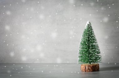 Dekoratif köknar ağacı, ahşap kızak ve gri zeminde kar içeren minimalist noel kompozisyonu. Tatil kavramı.