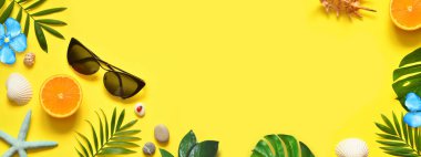 Yaz dönemi. Palmiye yaprağı, portakal, deniz yıldızı ve sarı arka planda deniz kabuğu. Seyahat et. Boşluğu kopyala.