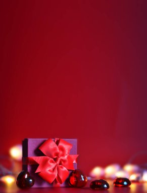 Sevgililer Günü afişi, el yapımı hediye kutusu, fiyonk ve kırmızı arka planda mesaj için yeri olan bir sürü kalp.