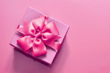 El yapımı hediye kutusu olan tatil konsepti afişi, metin için yeri olan mor bir arkaplan üzerine eğilin