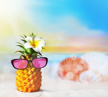 Çiçekli ananas ve plajda güneş gözlüğü. Yaz plajı konsepti.
