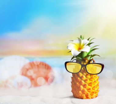 Çiçekli ananas ve plajda güneş gözlüğü. Yaz plajı konsepti.