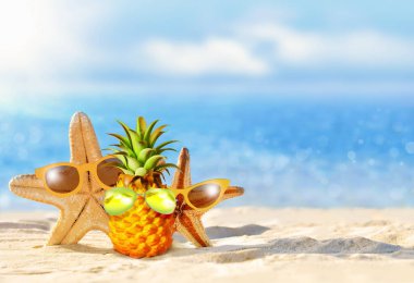 Sahilde güneş gözlüklü ananas ve denizyıldızı. Yaz plajı konsepti.