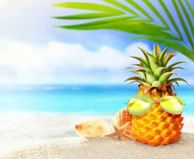 Pineapple with sunglasses and palm in the beach. Summer beach concept.