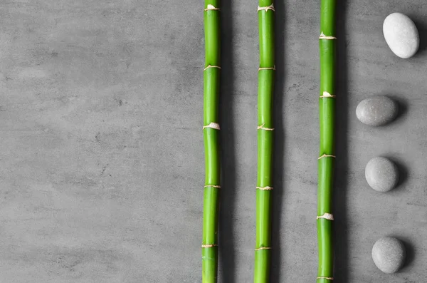 Bamboo and spa stones on grey background. Spa concept.