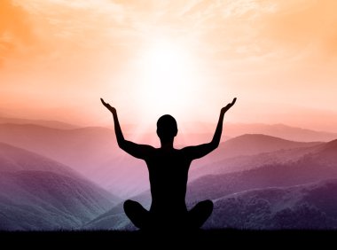 Yoga and meditation. Silhouette of man on the mountain.