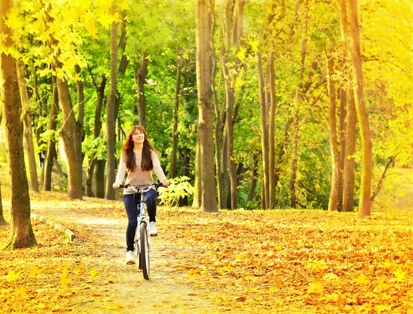 Jeune fille à vélo sur la route dans le parc — Photo