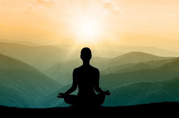 Yoga silhouet op de berg in zonnestralen — Stockfoto