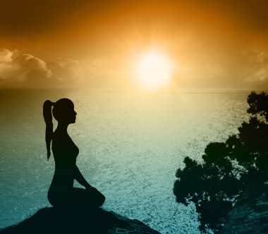 Sahilde bir kadınla silüeti. Yoga ve meditasyon.