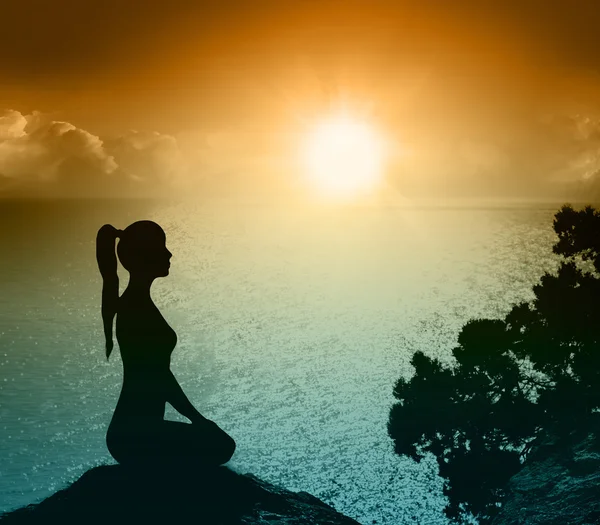 Sahilde bir kadınla silüeti. Yoga ve meditasyon.