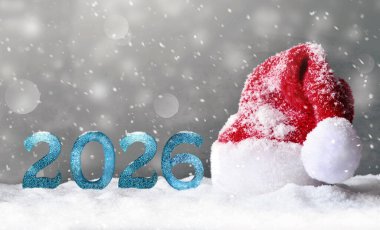 Gri arka planda Noel Baba şapkası. Mutlu yıllar 2026