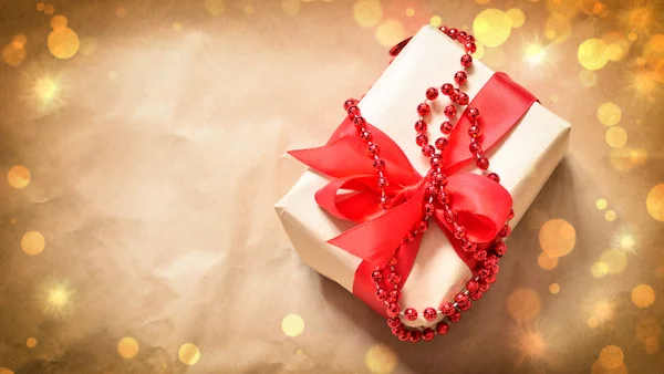Gift box tied red ribbon. Old wooden background. — Stock Photo, Image