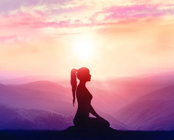 Silueta de una mujer practicando yoga en las montañas — Foto de Stock