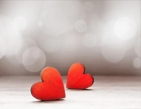 Red wooden hearts against defocused lights. — Stock Photo, Image