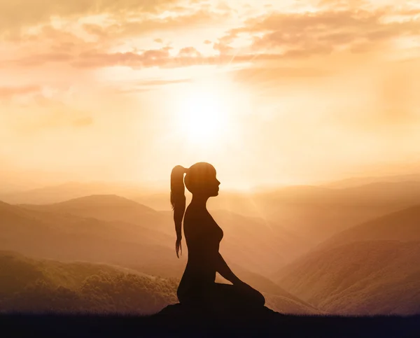 Nő a hegyekben meditál. Sziluettjét. — Stock Fotó