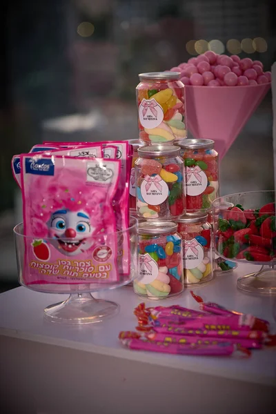 Tel Aviv, İsrail 2.08.2025 'te bir terasta 12. doğum gününü kutlayan güzel bir genç kız. Elinde bir buket pembe gül tutuyor ve sıcak altın gün batımı ışığında gülümsüyor. Zarif pastel tonlar, şenlikli atmosfer ve doğal