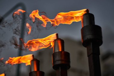 Musevi ışık festivali sırasında bir Hanuka menorasında mum yaktı. İnancı, geleneği, maneviyatı, kutlamayı ve dini kültürü temsil eden geleneksel Yahudi bayramı sembolü. Sıcak ateş alevleri ve akşam atmosferiyle yakın çekim.