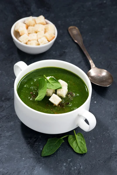 Крем-суп зі шпинатом з грінками на темному фоні, вертикальний — стокове фото