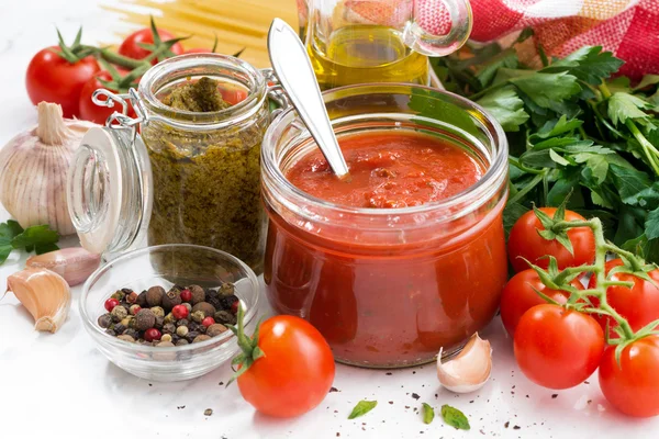 Томатный соус, песто и ингредиенты для макарон на белом столе — стоковое фото