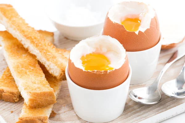 Huevos cocidos y tostadas en una tabla de madera —  Fotos de Stock