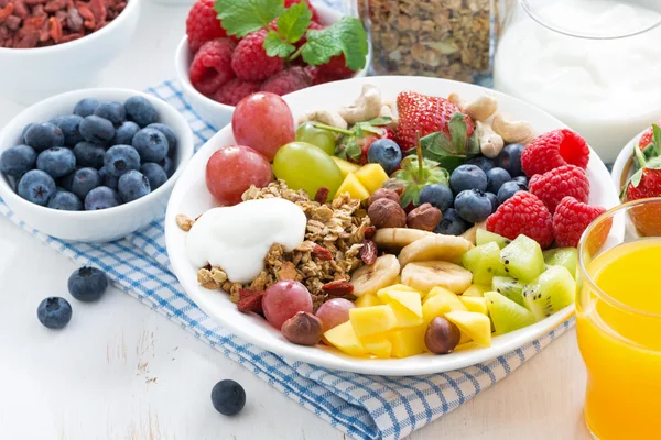 Beeren, Früchte, Nüsse und Müsli auf dem Teller Stockbild