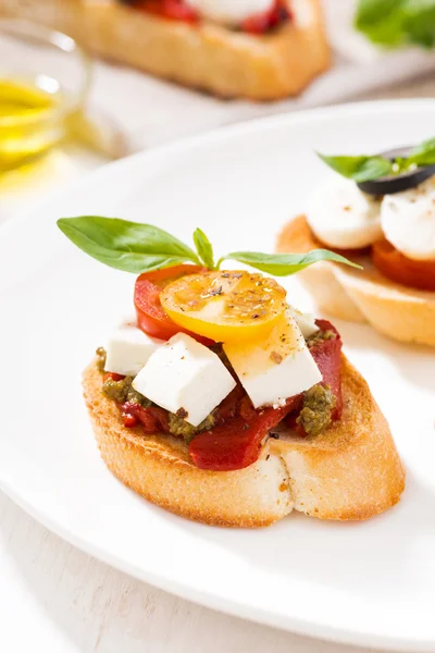 Bruschettas med tomater och mozzarella på plattan, vertikal — Stockfoto