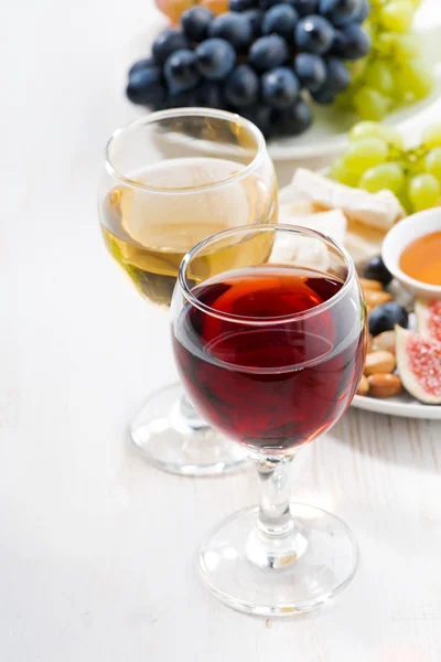 Glazen met wijn en hapjes op witte tafel — Stockfoto