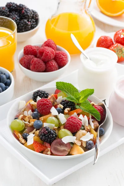 Macedonia di frutta in una ciotola e vari yogurt, verticale, vista dall'alto — Foto Stock